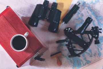 Toned background with cup of coffee and blurred navigation equipment. Sea travel tourism concept.