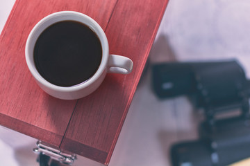 Toned background with cup of coffee and blurred navigation equipment. Sea travel tourism concept.