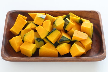 Chopped pumpkin on wooden plate