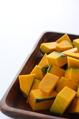 Chopped pumpkin on wooden plate