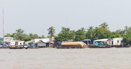 Fototapeta na wymiar Cai Be, Vietnam-December 10, 2013. Vietnamese men on the cargo boat transfer huge load of processed rice cereals on the Mekong river part of Cai Be town on December 10, 2013 at Mekong Delta in Vietnam