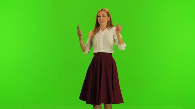 Extremely happy dance by a stylish woman after getting some incredible news in her phone, over a green screen.