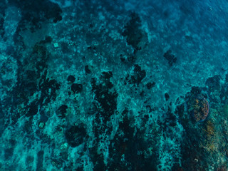 Turquoise ocean water with coral reef, aerial drone shot. Top view