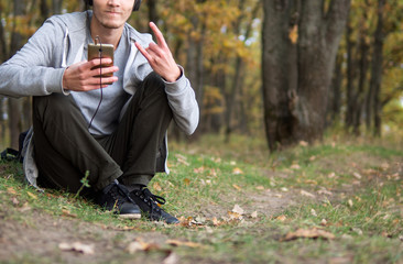Young Caucasian man listening to music in headphones in nature
