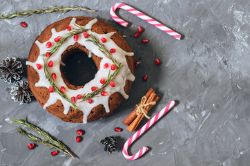 Homemade chocolate Christmas cake decorated with rosemary and pomegranate, top view with copy space