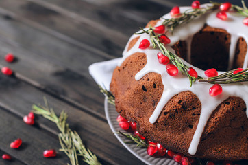 Homemade chocolate Christmas cake decorated with rosemary and pomegranate, front view