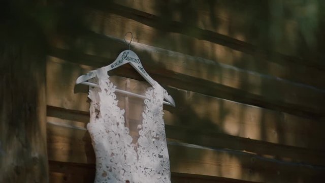 Wedding dress hanging outdoor.white wedding dress hanging on a wooden house and the wind sways the dress.