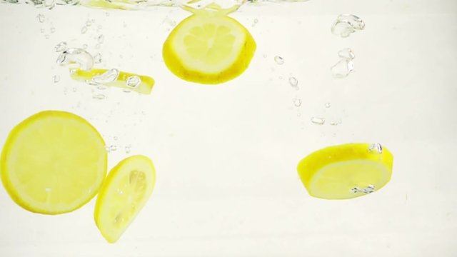 Lemon lemonade with slices of fresh citrus, slow motion close-up