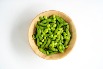 Green soybeans on a wooden bowl