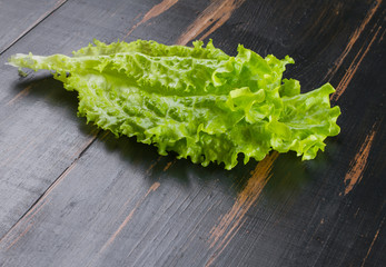 leaf of lettuce on wooden dark tabletop