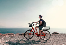 Young beautiful girl woman travels by bicycle on a mountain landscape on the beach in the sun, tourism and leisure concept, Greece, Kos