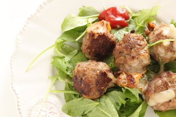 homemade meat ball served with baby leaves and ketchup