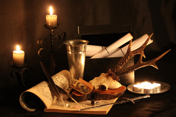 Antique Magic Book. Witchcraft Peacock feathers and candle background. Black candle Magic Ritual.