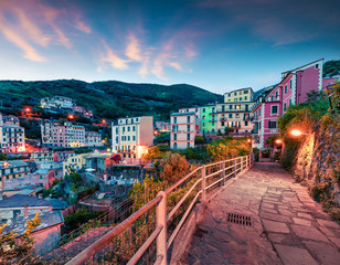 First city of the Cique Terre sequence of hill cities - Riomaggiore. Colorful spring sunset in  Liguria, Italy, Europe. Great evening seascape of Mediterranean sea. Traveling concept background.