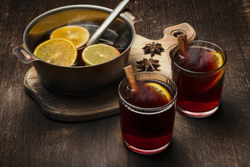 Glasses with hot mulled wine and a bowl for the preparation of a beverage