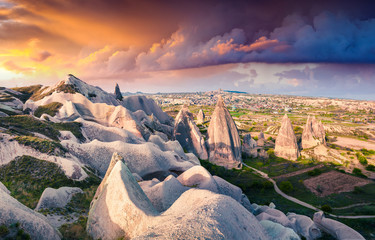 Unreal world of Cappadocia. Dramatic sunrise in Red Rose valley in April. Cavusin village located,...