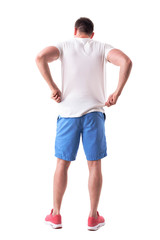 Back view of young handsome man adjusting and putting on summer clothes. Full body isolated on white background. 