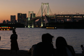 Fototapeta na wymiar View from Odaiba Beach to Tokyo Bay with Rainbow Bridge at dusk, Tokyo, Japan