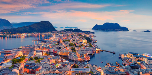 From the bird's eye view of Alesund port town on the west coast of Norway, at the entrance to the Geirangerfjord. Colorful sunset in the Nord. Traveling concept background. - obrazy, fototapety, plakaty