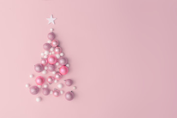 Christmas composition. Christmas tree made of pink ball decoration on pink table background. Flat lay, top view, copy space. New Year sale card.