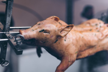 Piglet on a spit, gourmet dish, grilled meat, barbecue, smoked. Selective focus, cool tones, space for text.