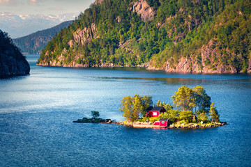 Picturesque summer view with small island with typical Norwegian building on Lovrafjorden flord,...