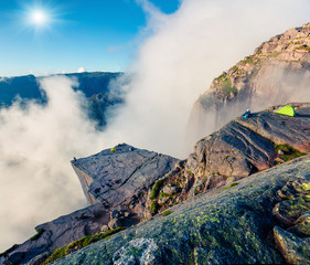 Foggy morning view of popular Norwegian attraction Preikestolen. Great summer scene of the Lysefjorden fjord, located in the Ryfylke area in southwestern Norway. Beauty of nature concept background.