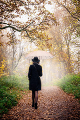 woman walking under an umbrella, back view