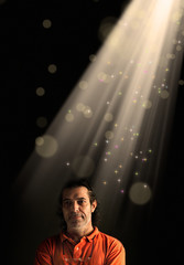 Conceptual portrait of adult man with beam of light and abstract light manipulation.