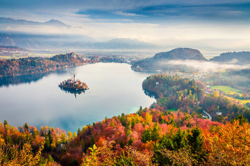 Aerial view of church of Assumption of Maria on the Bled lake. Foggy autumn landscape in Julian Alps, Slovenia, Europe. Beauty of countryside concept background.