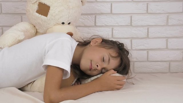 Portrait of a sleeping girl with a bear.