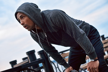 Tired because of running. Young jogger is stopped to catch his breath