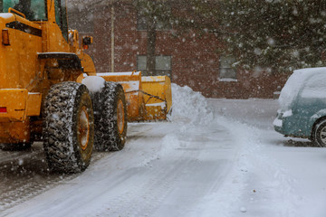 The bulldozer cleans the road after a blizzard