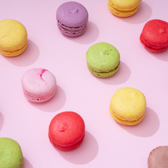 Pastel pink table top with colorful macarons pattern. Minimal sweet food concept. Cookie concept.