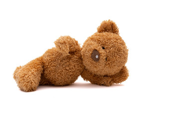 lying teddy bear isolated on white background