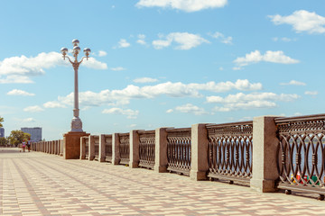 Beautiful forged fence on the embankment of the Volga River against a blue sky background with...