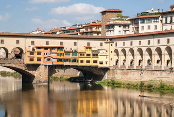 Obraz premium Riverboat with floating on river Arno near famous bridge of ancient Tuscany city