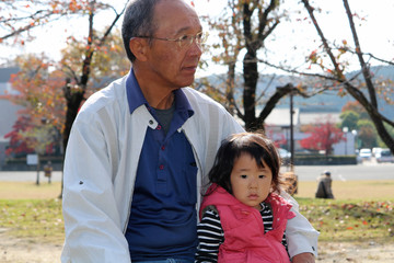 秋の公園　おじいさんと孫