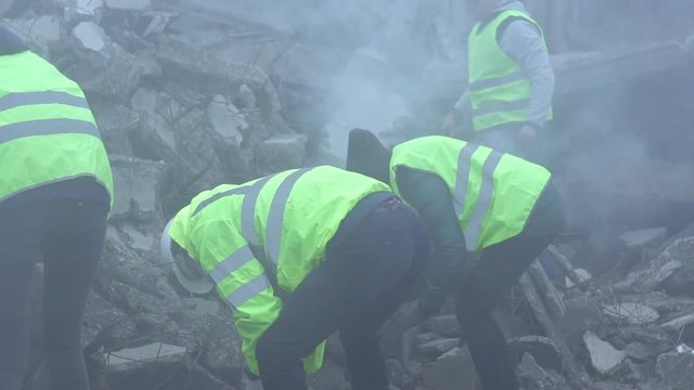 a group of rescue workers dismantle the rubble of the destroyed house after the earthquake