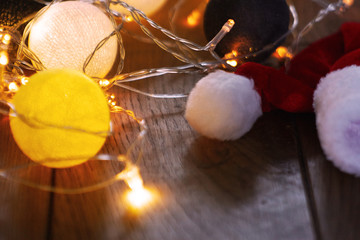 garland and Christmas hat lie on a wooden surface
