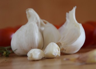 Frischer weißer Knoblauch und Mini Cherry Tomaten auf einem hölzernen Schneidebrett