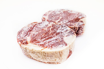 Frozen rib eye steak on white background
