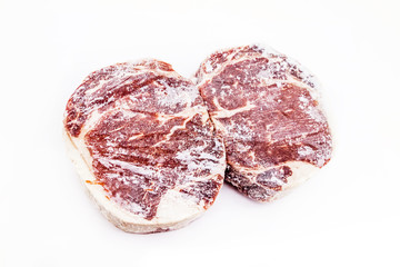 Frozen rib eye steak on white background