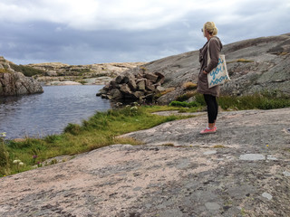 Single young blonde girl traveller looking out to sea hipster landscape nature