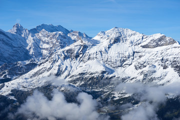 Winter mountain snowy peaks over clouds in the valley. Jungfrau region in Switzerland.