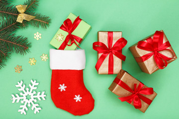 Santa's boot, gift boxes, fir tree branches with cones and snowflakes