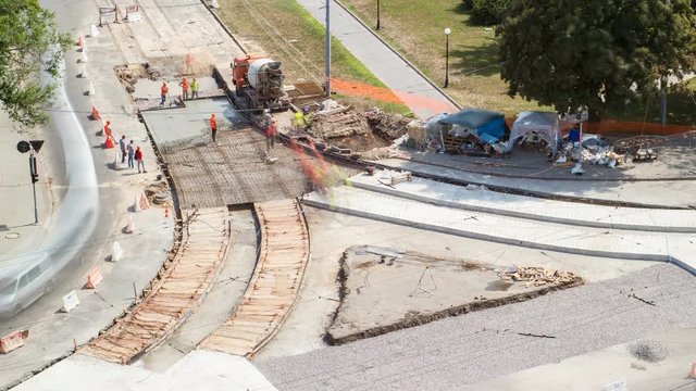 Concrete works for road maintenance construction with many workers and mixer timelapse