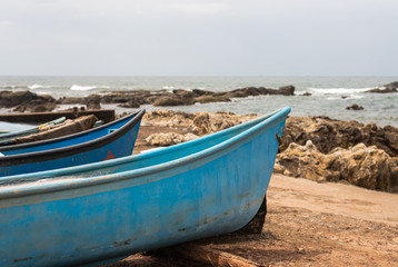 Fototapeta na wymiar Fishing boat docked on a rocky shore in Vagator Goa