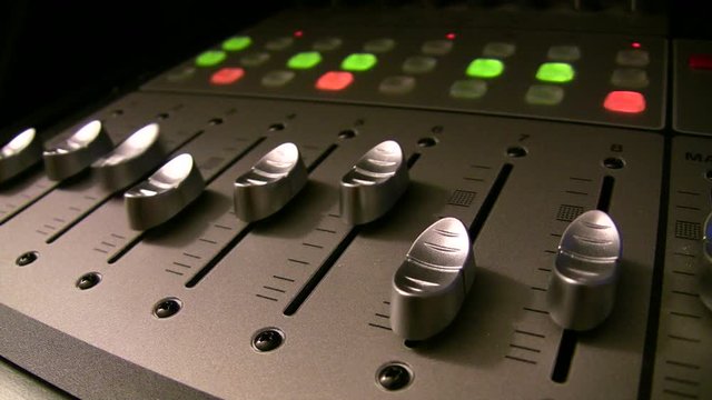 audio mixing board faders in motion for music looping