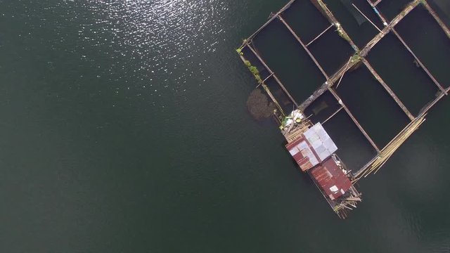 Sampaloc Lake, San Pablo City, Laguna, Philippines - November 21, 2017:  Bamboo fish cages built in the middle of mountain lake. Drone aerial shot
